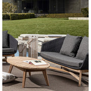 Medence partján álló design kertibútor szett, ovális teakfa dohányzóasztallal.