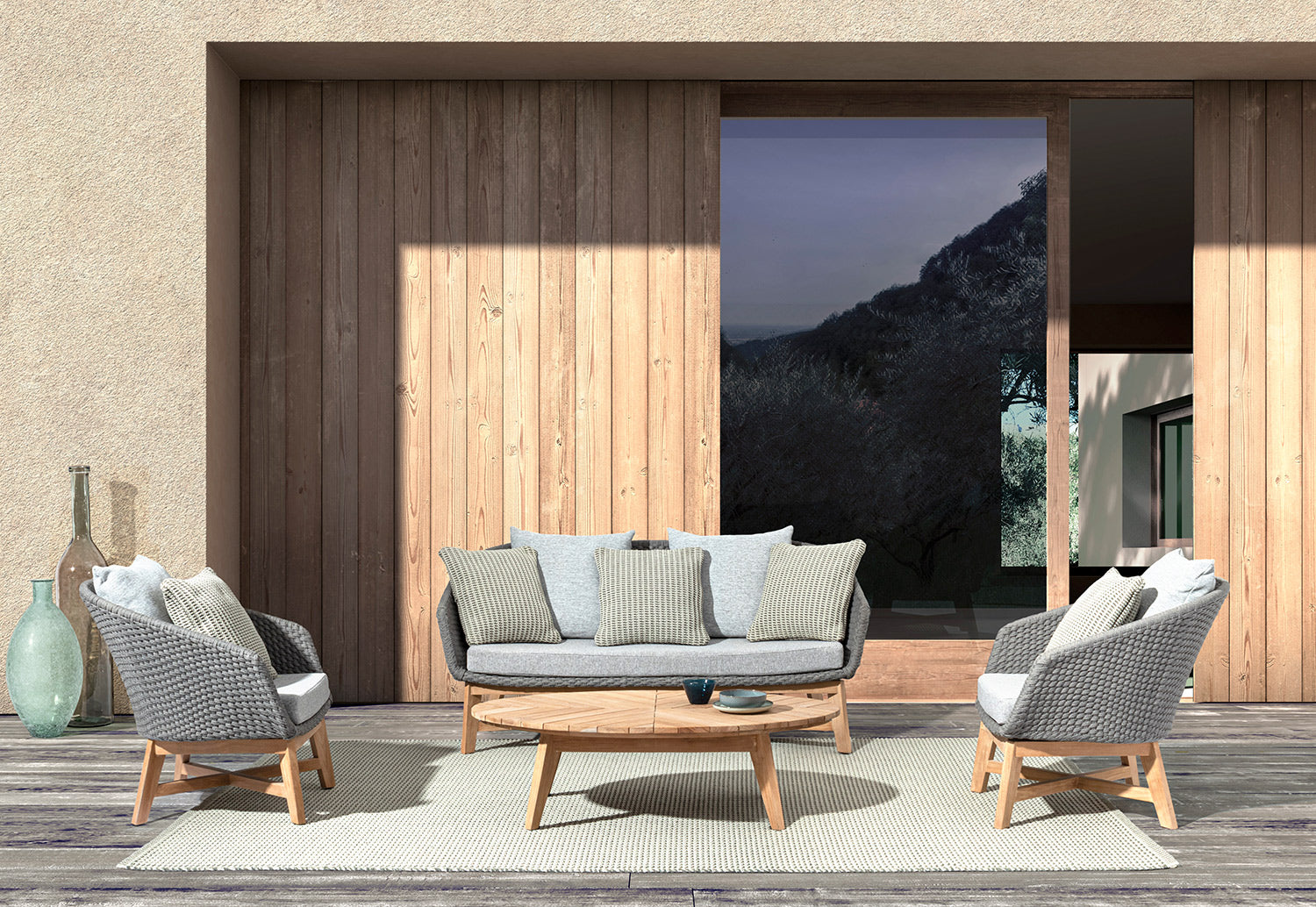 Teraszon álló négyrészes design kerti bútorgarnitúra két fotellel, kanapéval és dohányzóasztallal.