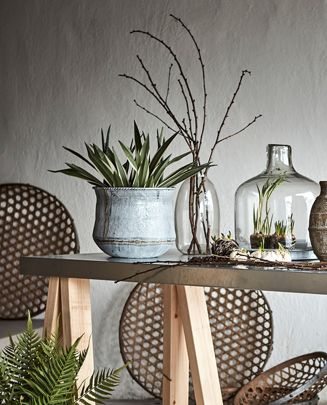 Vidéki stílusú szobabelső asztallal, üvegpalackokkal és bádogkaspókkal.