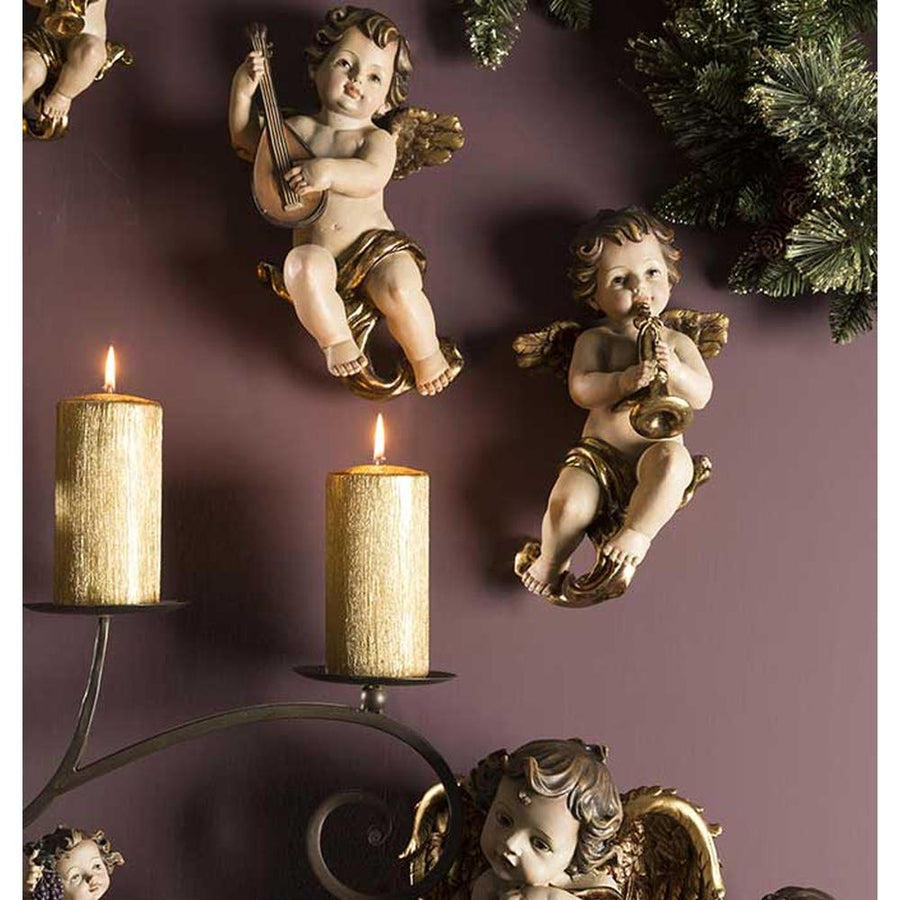 Barokk stílusú, 34 cm magas, falra függeszthető harsonás angyal figura lila színű karácsonyi falon. 