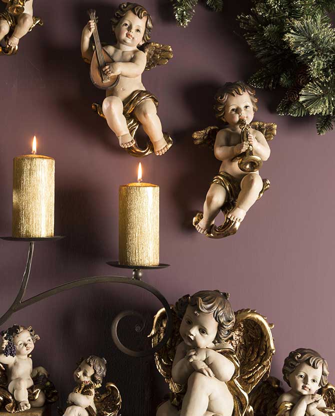 Karácsonyi angyalkák lila színű falon arany gyertyával