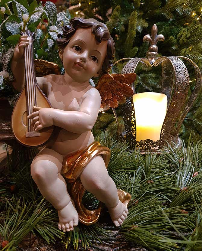 Lanton játszó, karácsonyi angyal puttó figura fenyőfa és fagyöngy között arany koronával 