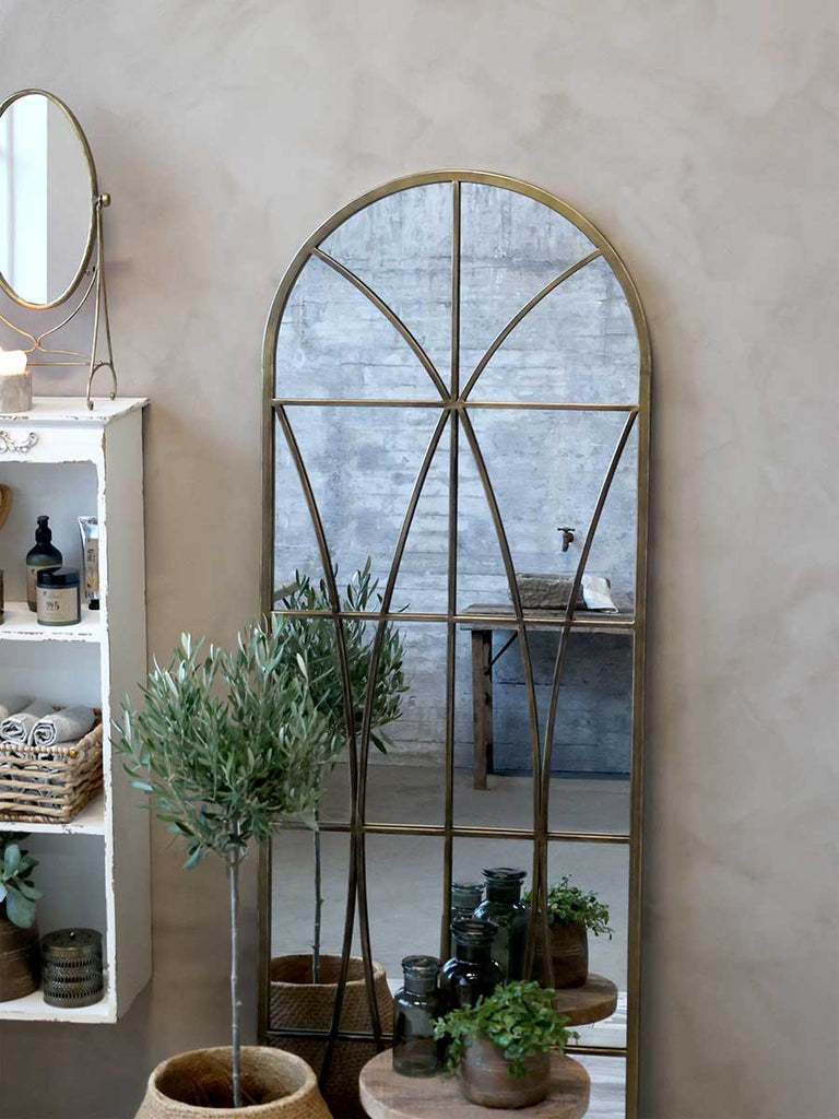 Loft stílusú fürdőszoba belső, növényekkel, falipolccal és nagyméretű tükörrel.