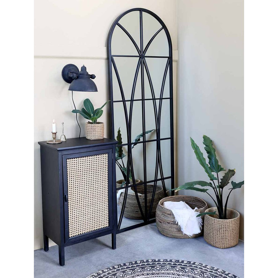 Loft stílusú szobában, komód valamint kosarak melett álló loft stílusú, fekete színű falitükör.