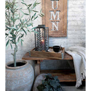 Loft stílusú szobában, lócán, fatálcán álló vintage stílusú fémlámpás pokróccal és teáscsészével.