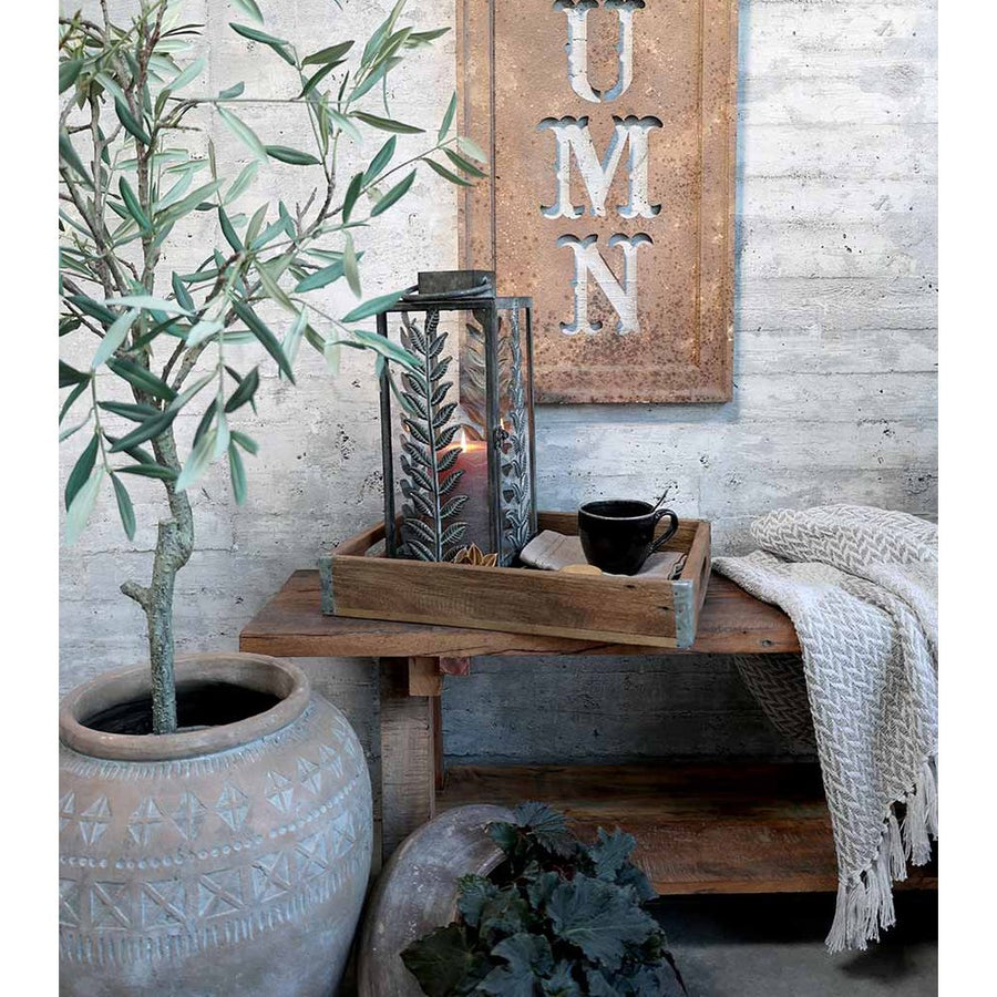 Loft stílusú szobában, lócán, fatálcán álló vintage stílusú fémlámpás pokróccal és teáscsészével.