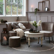 Klasszikus stílusú nappalibelső, tejeskávé színű ülőgarnitúrával és fehér színű kerek dohányzóasztallal.