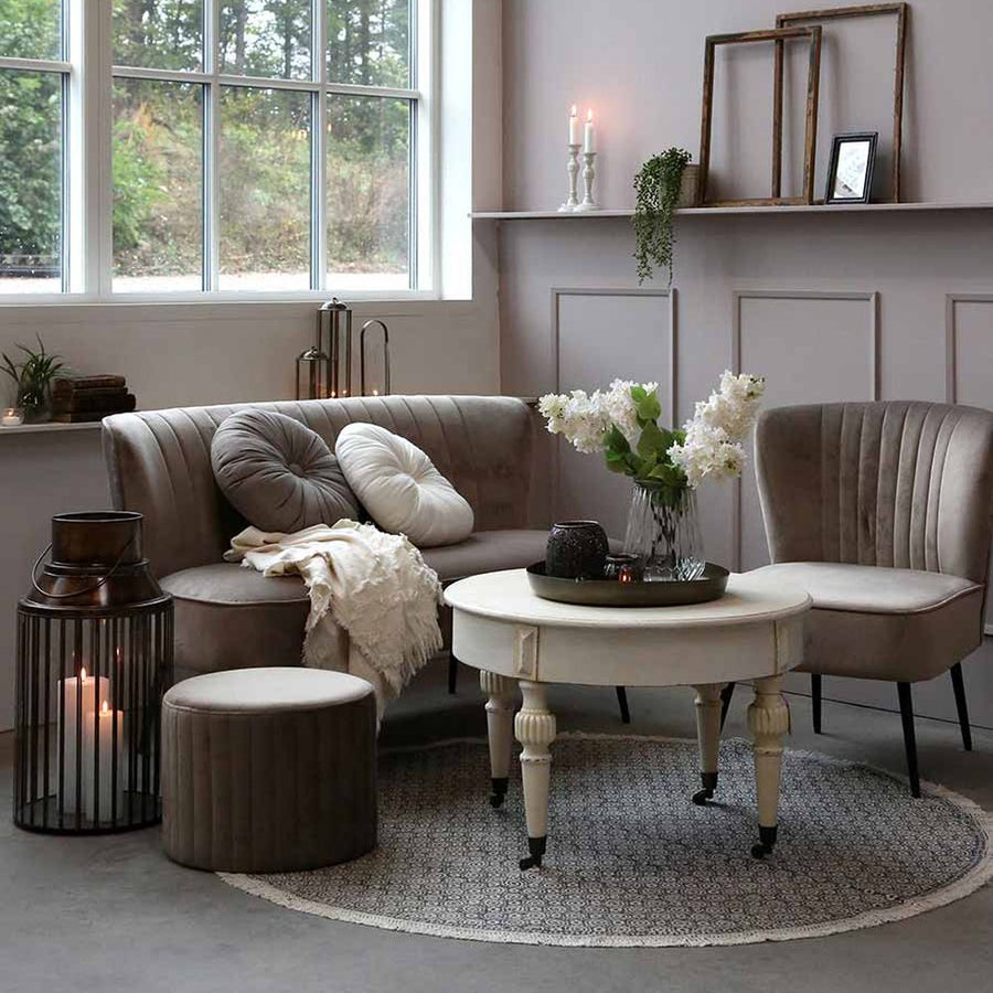 Klasszikus stílusú nappalibelső, tejeskávé színű ülőgarnitúrával és fehér színű kerek dohányzóasztallal.