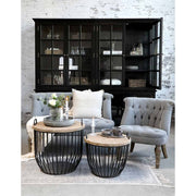 Vidéki stílusú nappaliban álló vintage stílusú kanap és fotel kalitkaszerű dohányzóasztallal.