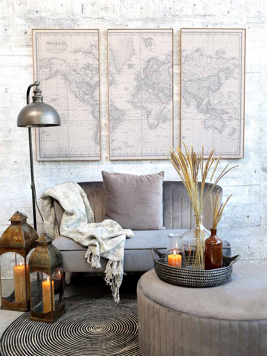 Loft stílusú nappali kanapéval, világtérképpel és és ipari stílusú állólámpával.