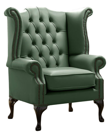 Lombzöld színű bőrrel kárpitozott Chesterfield szárnyas fotel.