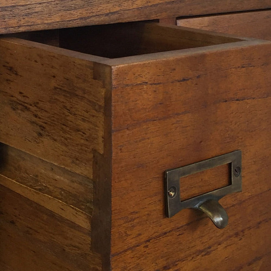 Bronzból készült süllyesztett fogantyúi és címkék tárolására alkalmas fémperselyek harmonikusan emelődnek ki a bútor alapszínéből.