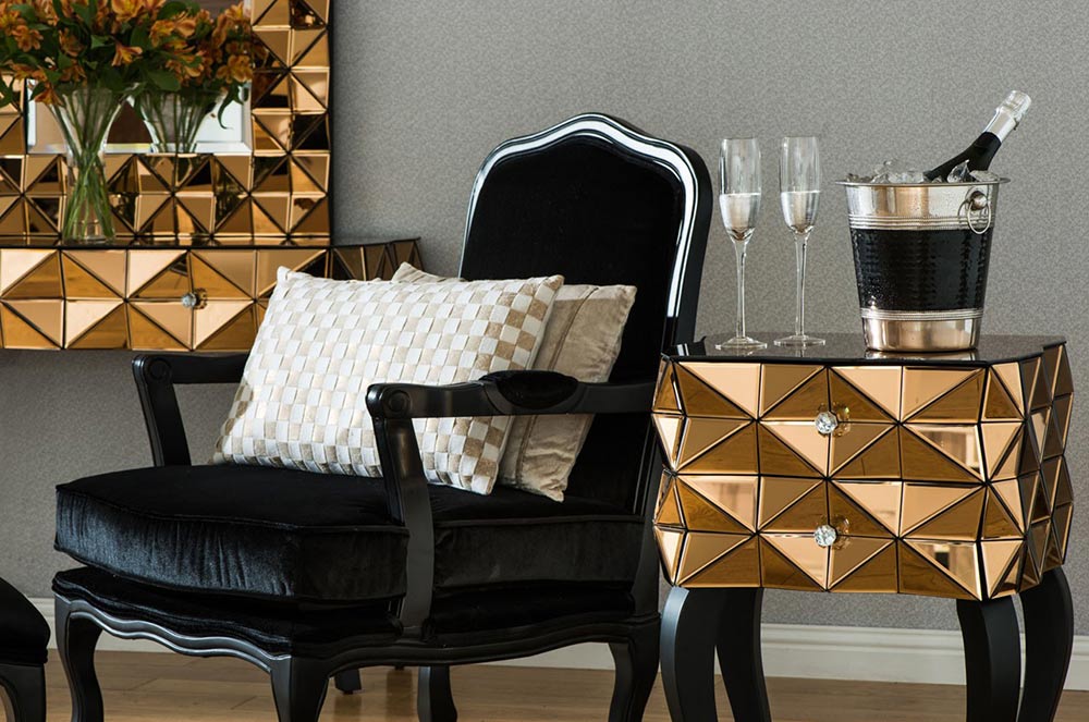 Fekete  barokk fotel, glamour arany kisasztallal, rajta pezsgősvödör és poharak. 