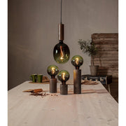 A Colourmix termékcsalád zöld izzói. Három izzó asztali dekorfoglalatban áll, a harmadik egy függesztéken lóg.