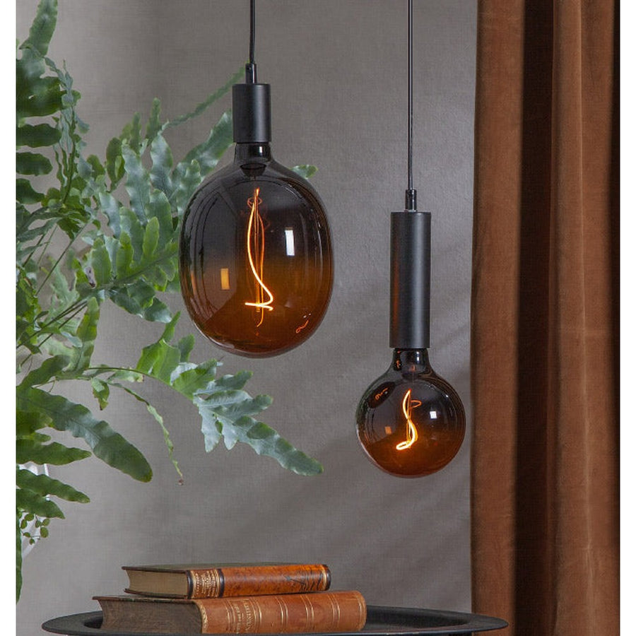 A Colourmix termékcsalád narancssárga izzói egy kisasztal felett lógnak.