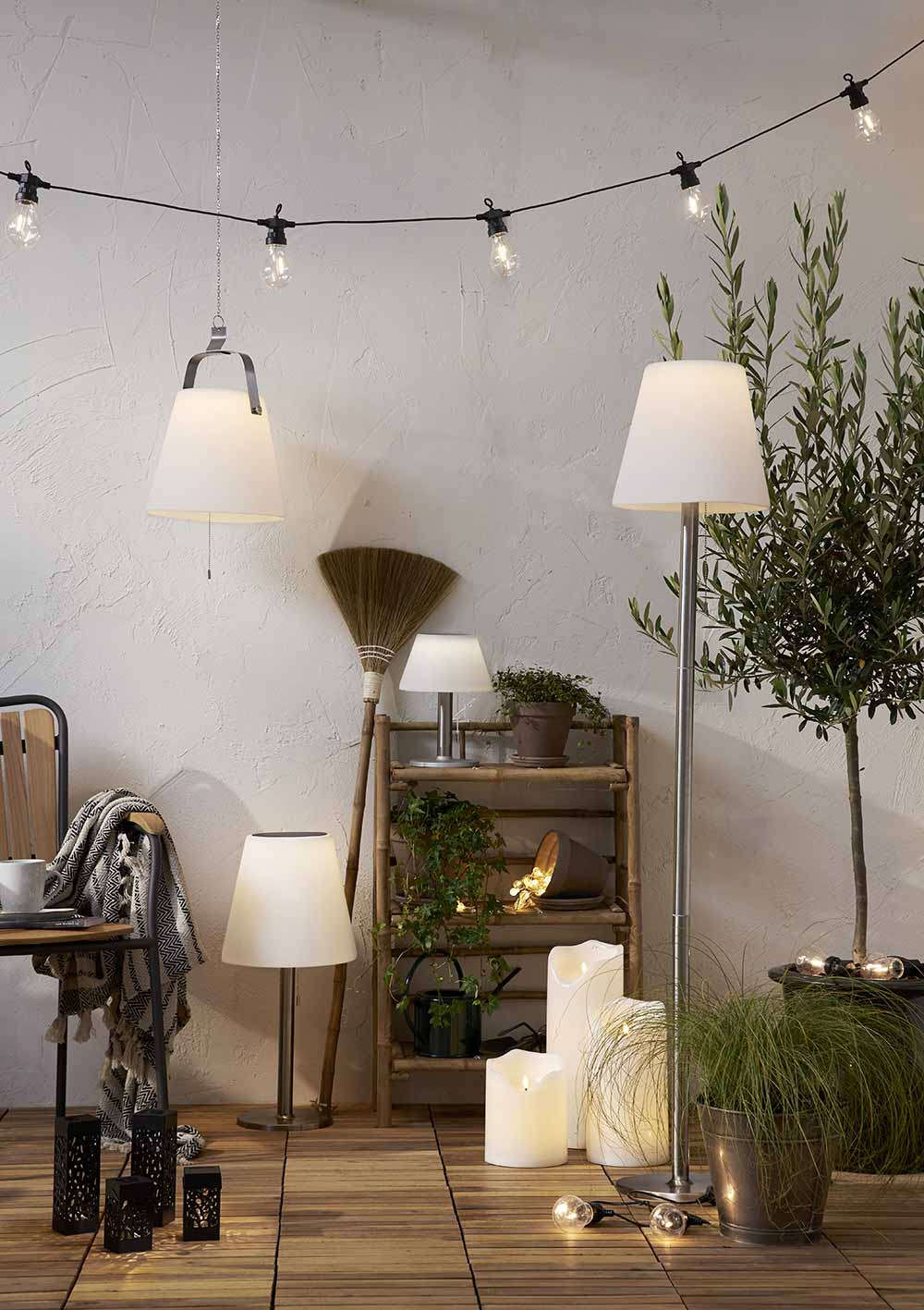 Cserepes növényekkel díszített szobabelső, polccal, LED gyertyákkal.