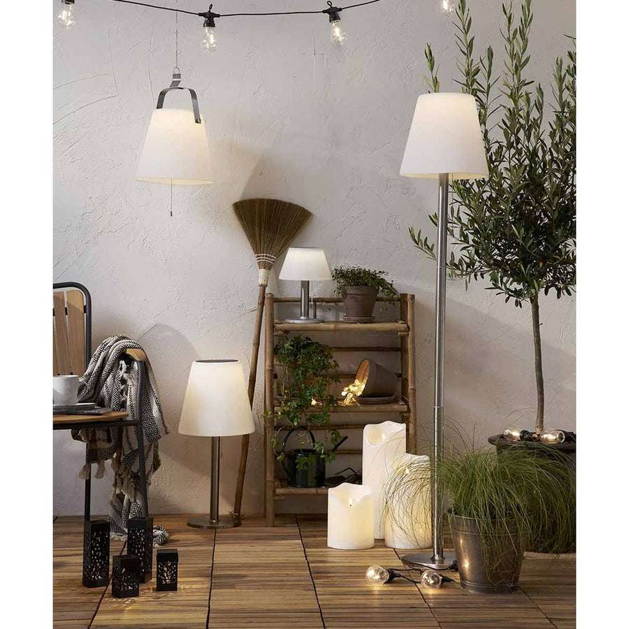 Cserepes növényekkel díszített szobabelső, polccal, LED gyertyákkal.