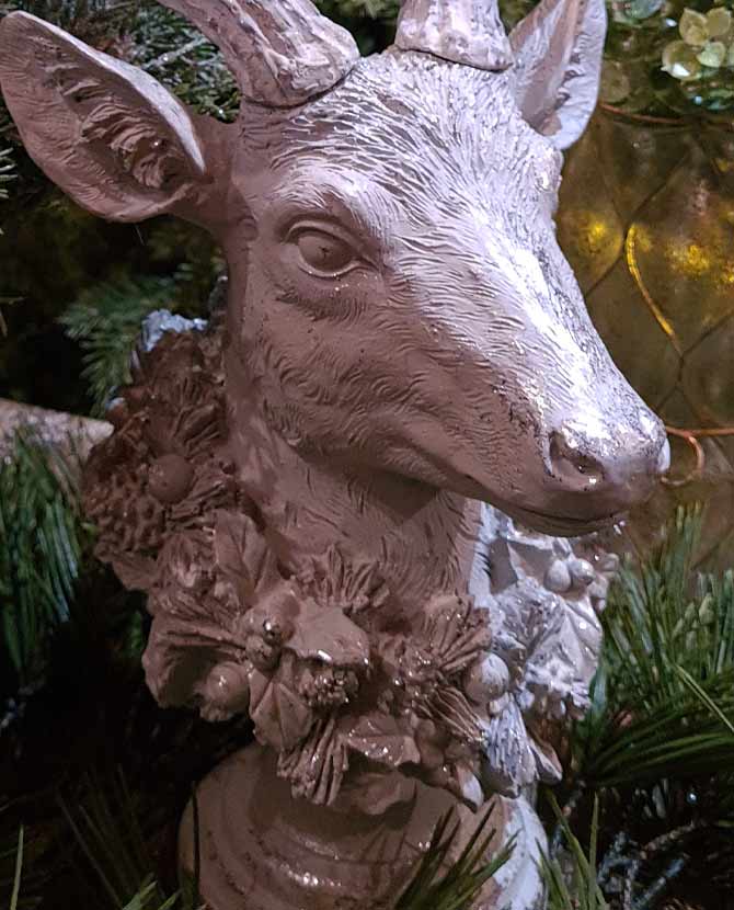 Prémium kategóriás, részletgazdagon kivitelezett glitteres karácsonyi szarvas koszorúval a nyakában fenyők között