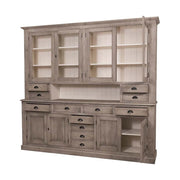 Nagyméretű, fenyőfa tálalószekrény. A tárolásról a négy darab üveges ajtó mögött található polcok, az esztétikusan elhelyezett tizenkét polc, valamint a két darab ajtós tároló mögött található tér gondoskodik. Az antikolókefével törént kezelésnek köszönhetően a bútor külső felületén gyönyörűen kirajzolódik a fa erezete, amit a szürkésbarna pác csak tovább erősít, míg a bútor belső felületeit krém színűre festették.