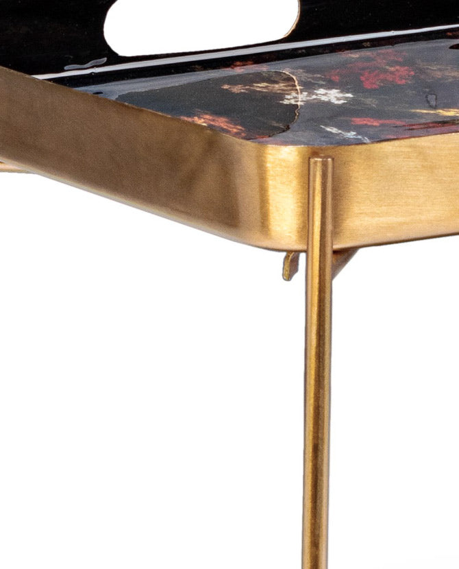 Acélból készült, modern stílusú kisasztal, zománcozott fedlappal és polccal, valamint arany színű lábakkal.