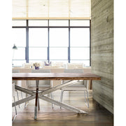 Modern stílusú otthonban álló akácfa étkezőasztal fényes krómhatású lábakkal.