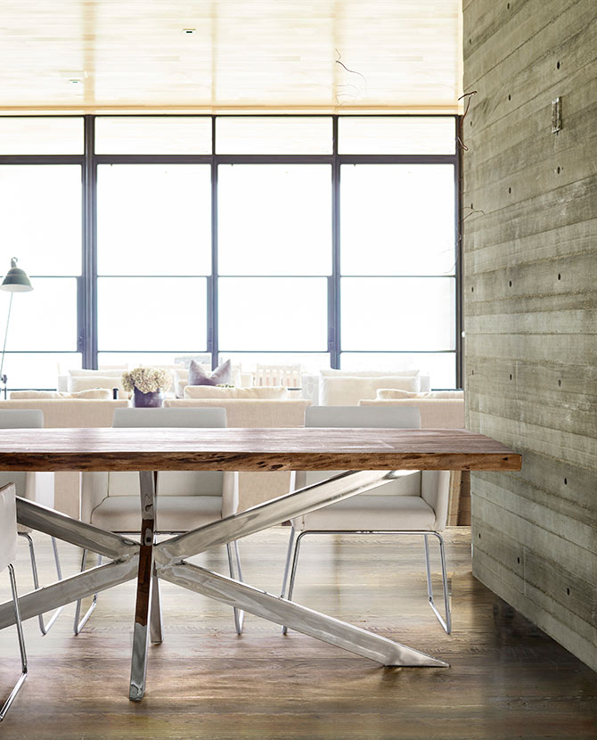 Modern stílusú otthonban álló akácfa étkezőasztal fényes krómhatású lábakkal.