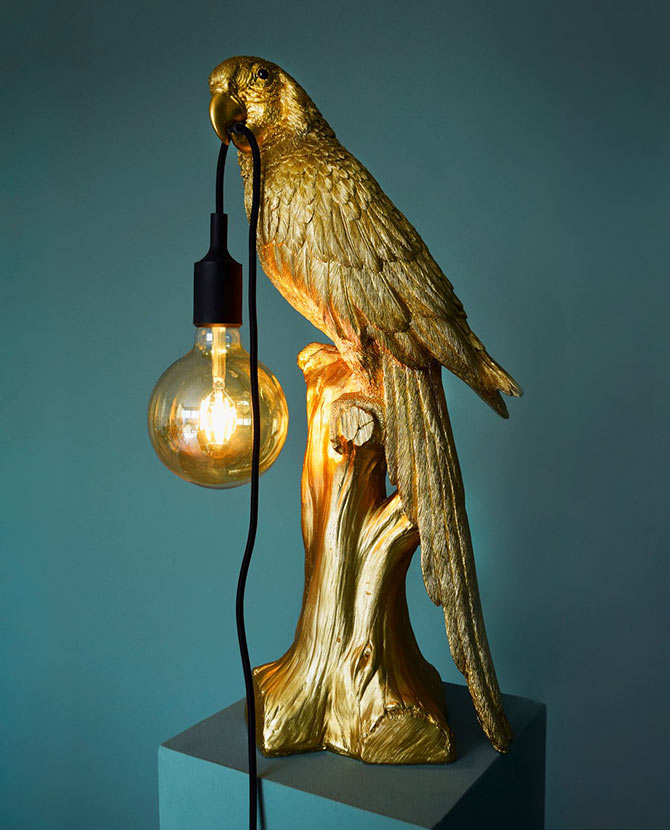 Aranyszínű papagáj figurás, 61 cm magas, trópusi, glamour stílusú asztali lámpa, szürkéskék háttér előtt.