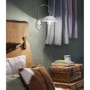 Festett motívumokkal díszített, mázas kerámiából és fémből készült kézműves falilámpa.