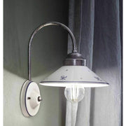 Festett motívumokkal díszített, mázas kerámiából és fémből készült kézműves falilámpa.