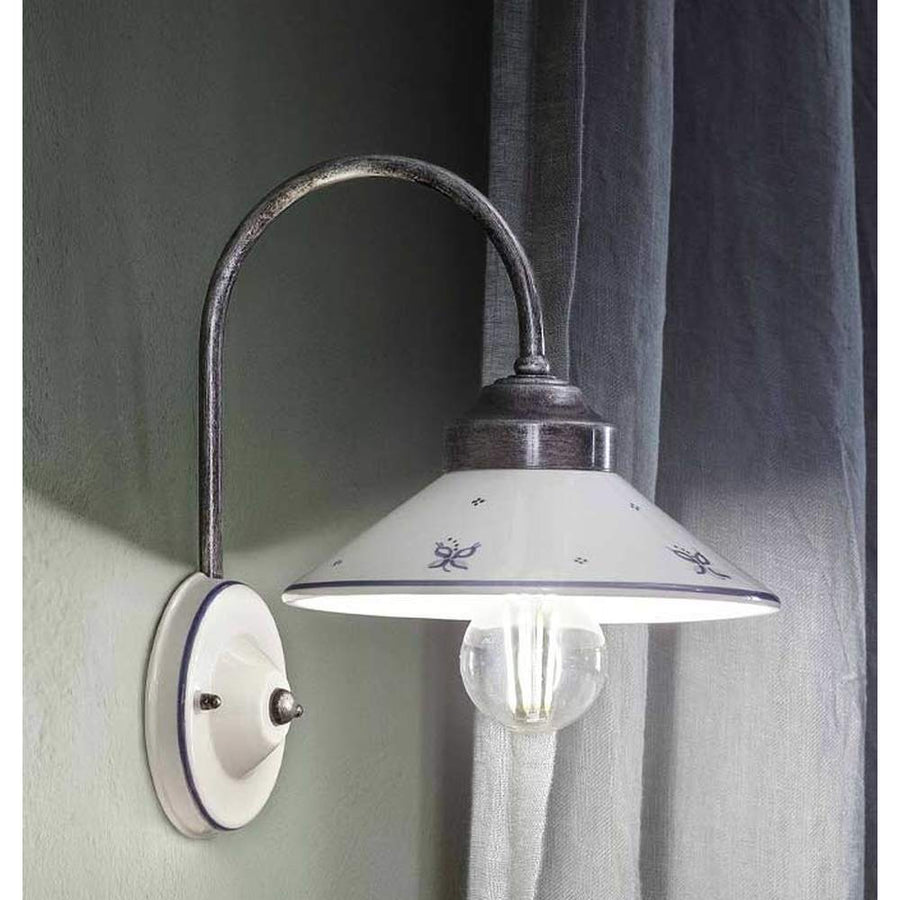 Festett motívumokkal díszített, mázas kerámiából és fémből készült kézműves falilámpa.