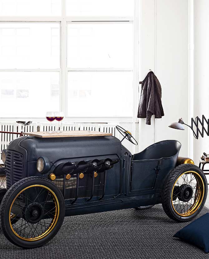 Kézzel épített élethű vintage verseny automobil formájú bortartó bárszekrény egy szoba közepén.