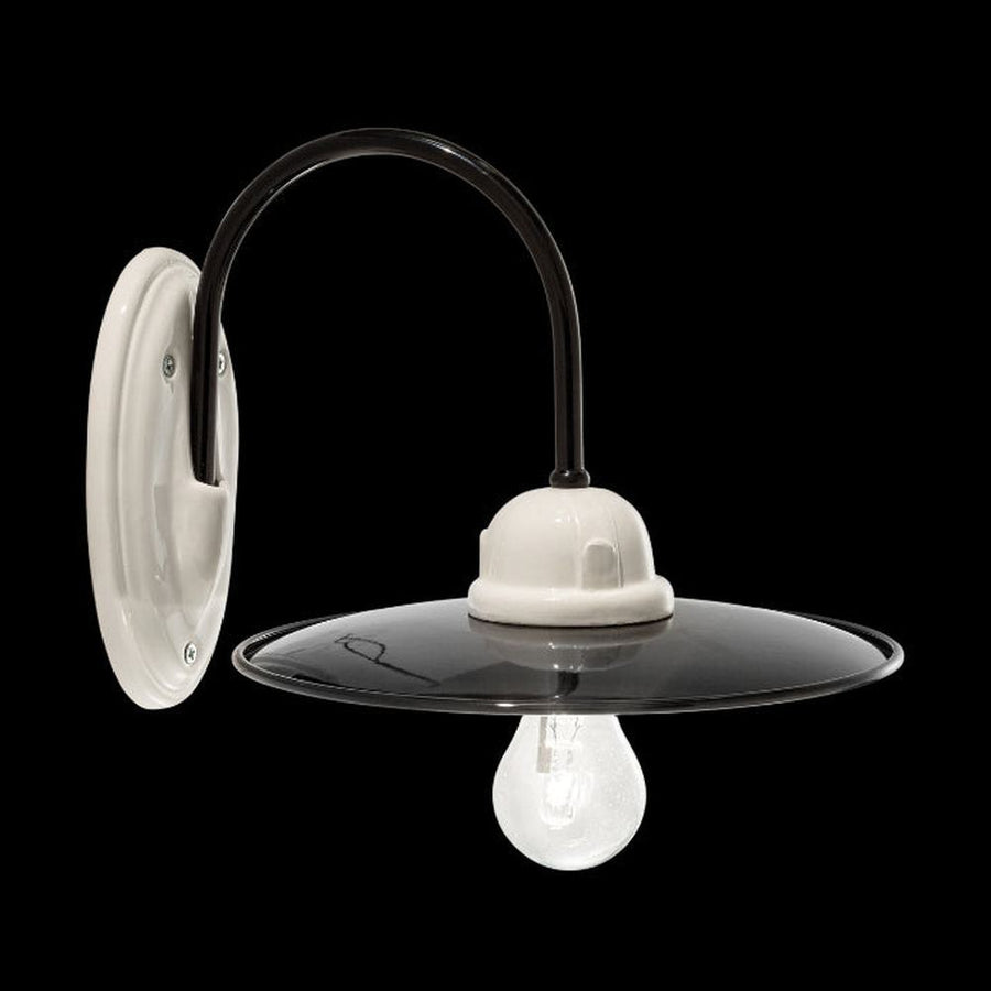 Vidéki stílusú, fekete színű mázas fémből és fehér színű mázas kerámiából készült, kézműves falilámpa.