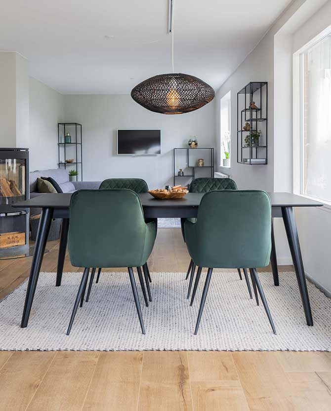 Modern stílusú étkező, köralakú, skandináv stílusú asztallal, zöld színű bársony étkezőszékekkel.