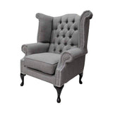 Palaszürke színű vászonnal kárpitozott Chesterfield fotel.