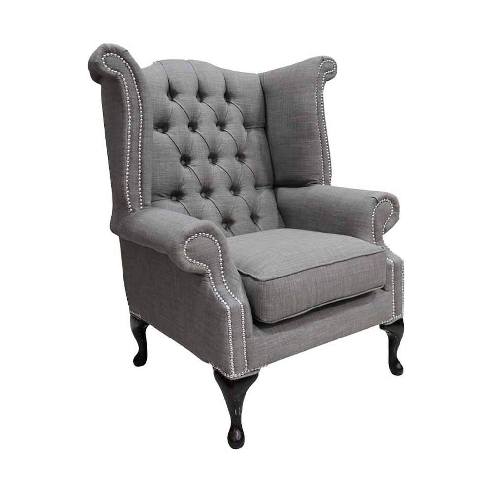 Palaszürke színű vászonnal kárpitozott Chesterfield fotel.
