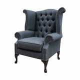 Sötétszürke színű vászonnal kárpitozott Chesterfield fotel.