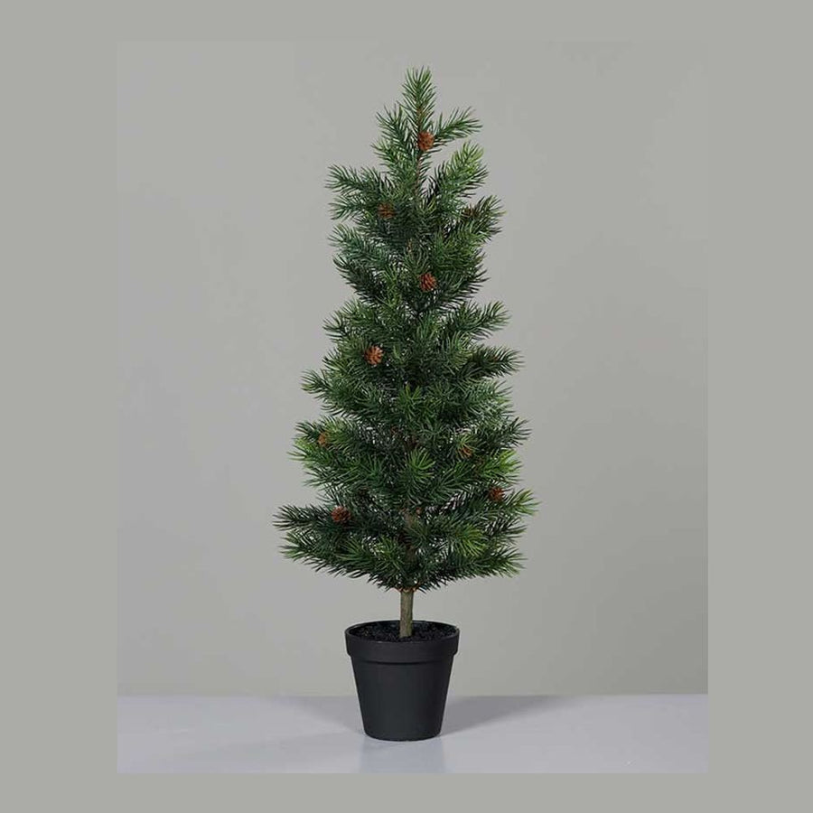 Mesterséges, 63 cm magas, tobozokkal díszített dekorációs műfenyőfa, fekete színű műanyag kaspóban szürke fal előtt