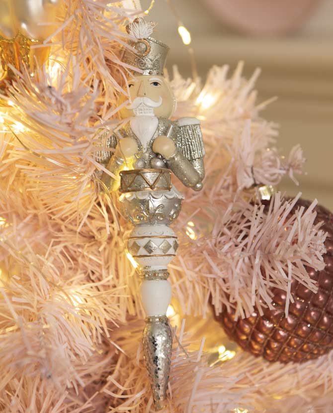 Jégcsap alakú, ezüst színű, diótörő figurás karácsonyfadísz.
