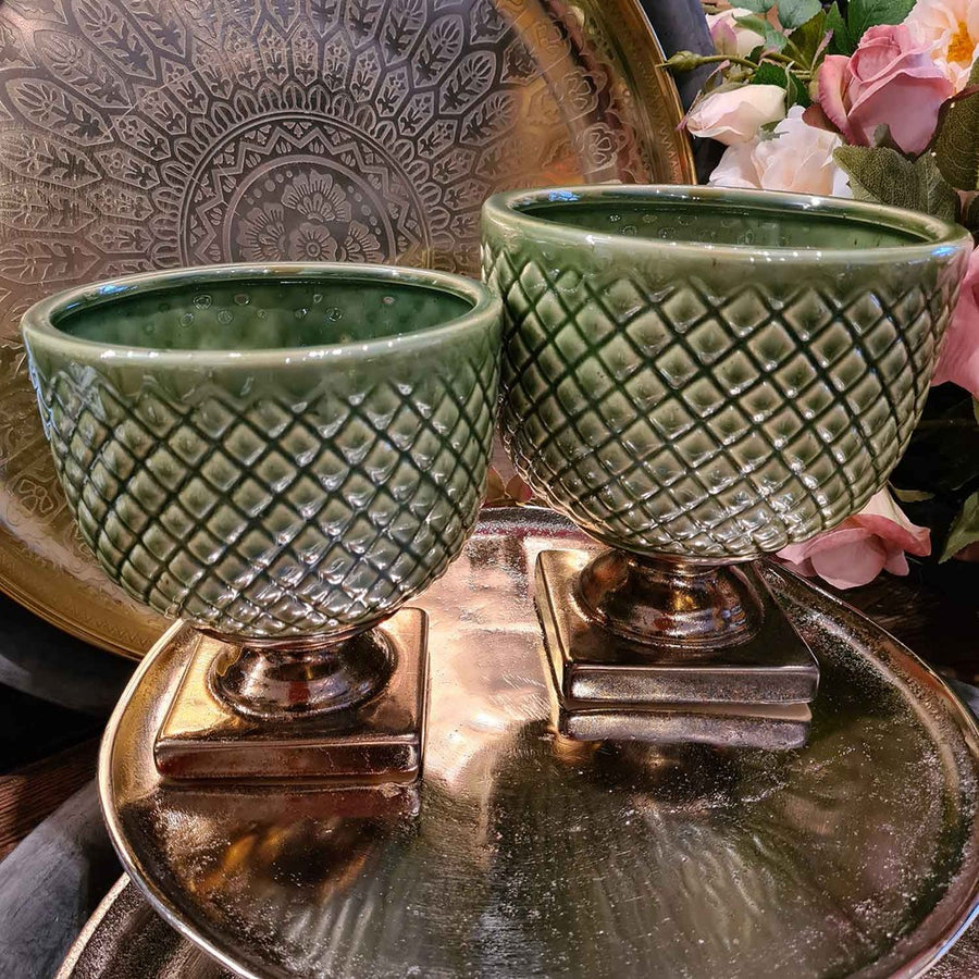 Két zöld, dombormintás Dalia kerámia kaspó bronzos talppal, elegáns környezetben, tálcán elhelyezve