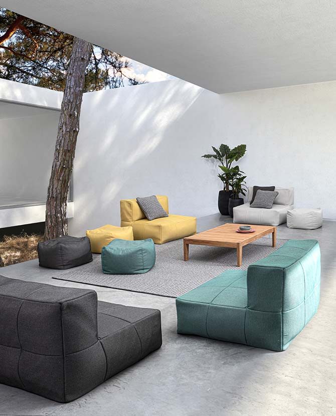 Modern, kortás formavilágú kerti fotelek és puffok egy átrium udvarában. 