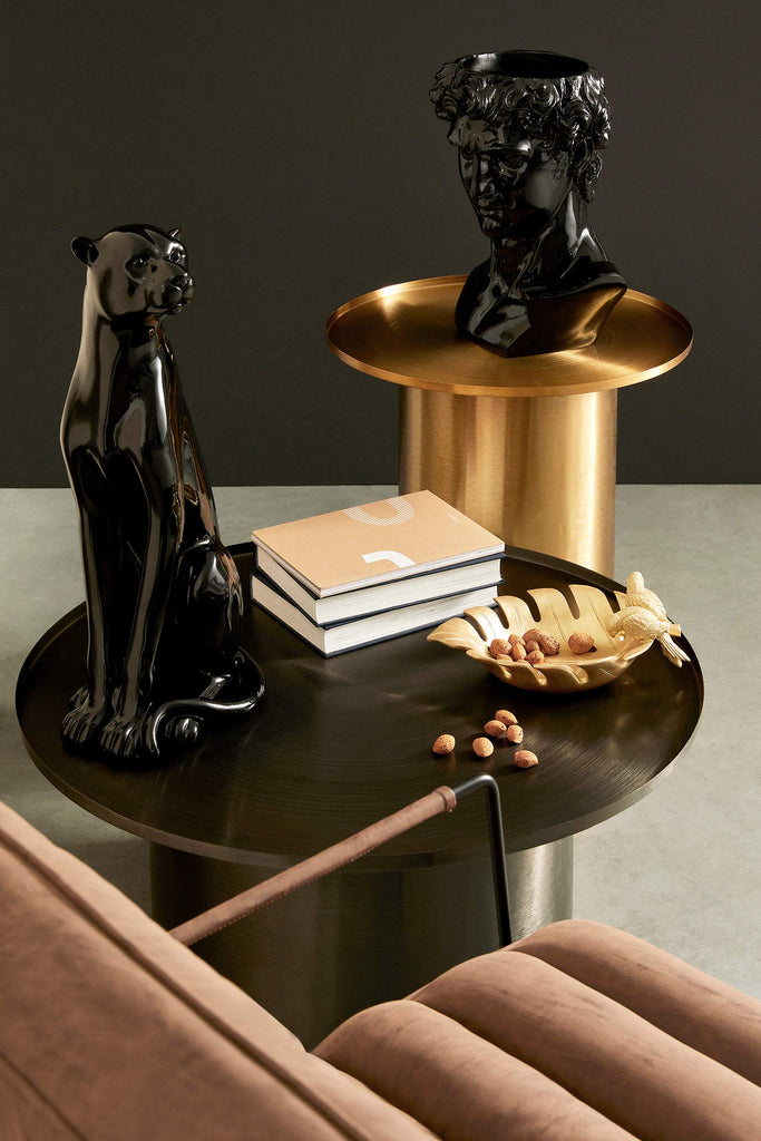 Modern, kortárs stílusú, fekete színű, nikkelezett acélból készült, kör alakú dohányzóasztal, féket színű szobrokkal.