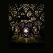 Fém töklámpás átvilágítva, csipke szerű árnyékkal a falon