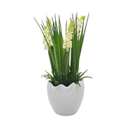 Krém színárnyalatú mű gyöngyike virág, tojás formájú, fehér színű kerámia kaspóban.