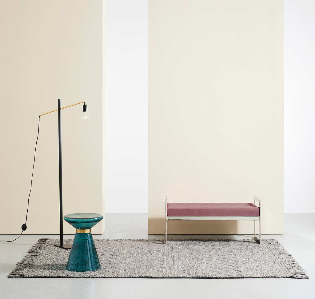 Barna szőnyeg, modern paddal, kék dohányzóasztallal és modern állólámpával.