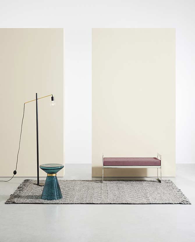 Barna szőnyeg, modern paddal, kék dohányzóasztallal és modern állólámpával.