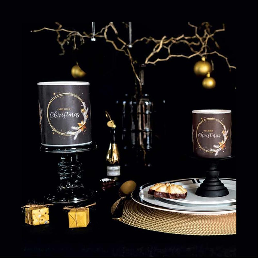 Fekete színű, arany gyűrűvel és csillagokkal díszített karácsonyi gyertyák ünnepi asztalon.