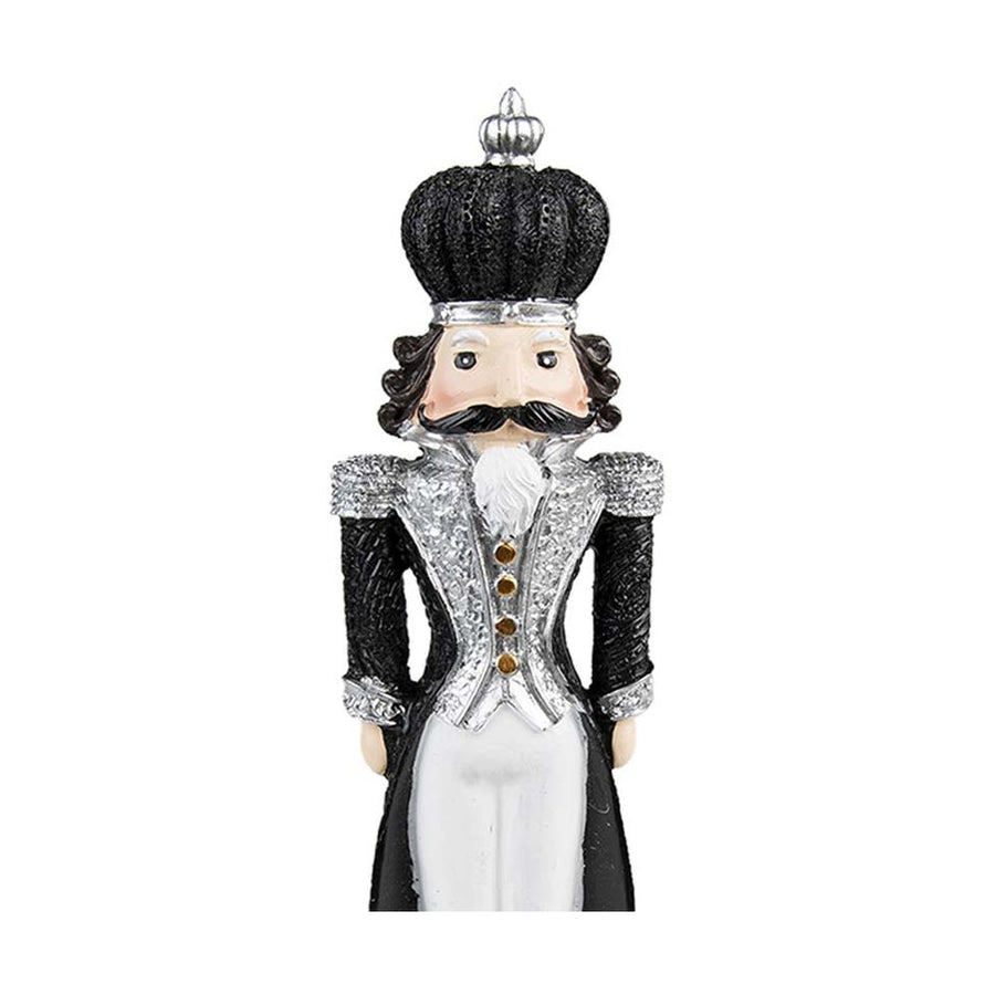 Barokkos díszítésű, 24 cm magas, díszes talapzaton álló, fekete és ezüst színű karácsonyi diótörő figura.