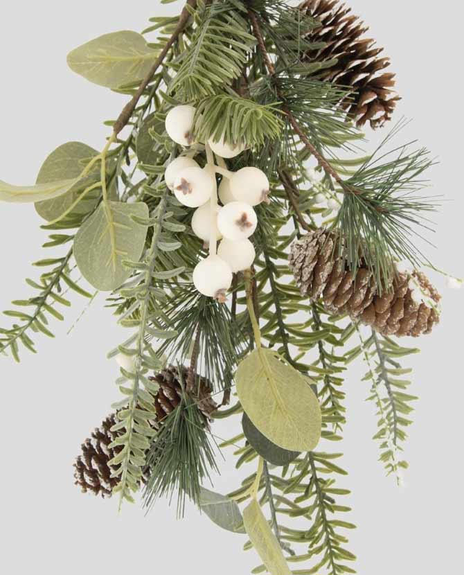 Eukaliptuszból, többféle fenyőágakból készült, fenyőtobozokkal és fehér bogyós terméssel díszített karácsonyi ajtódísz.
