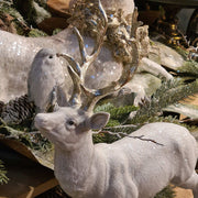 Glamour stílusú, fehér színű, deres hatású, ezüst agancsú és patájú exkluzív karácsonyi szarvas.