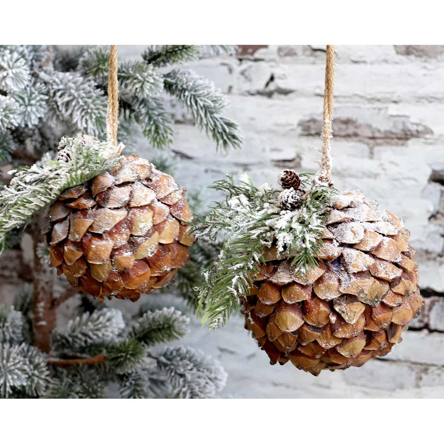 Kétféle méretű, vidéki stílusú,, fenyőággal díszített, havas felületű, karácsonyi toboz gömb dísz.